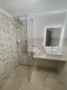 een badkamer met een douche, een wastafel en een spiegel bij Apartma Toni Bovec in Bovec