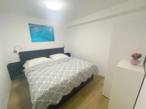 een slaapkamer met een bed in een witte kamer bij Apartma Toni Bovec in Bovec