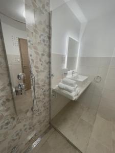 een badkamer met een wastafel en een douche met een spiegel bij Apartma Toni Bovec in Bovec