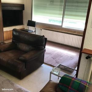 a living room with a leather couch and a table at Maison de 4 chambres avec vue sur la ville et jardin clos a Villeneuve les Avignon in Villeneuve-lès-Avignon