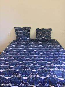 a bed with a blue and white comforter on it at Maison de 4 chambres avec vue sur la ville et jardin clos a Villeneuve les Avignon in Villeneuve-lès-Avignon
