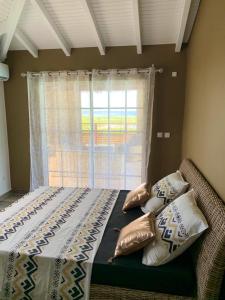 a bedroom with a bed with pillows and a window at Villa de 4 chambres avec vue sur la mer piscine privee et jacuzzi a Le Marin a 3 km de la plage in Le Marin