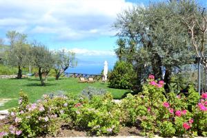 un giardino fiorito e un faro sullo sfondo di Sorrento View Villa a Sorrento
