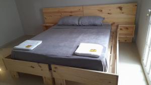 a wooden bed with two towels on top of it at Departamento de 2 dormitorios con Terraza y Asador in Santiago del Estero
