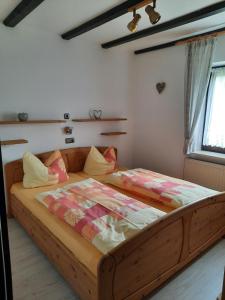 ein Schlafzimmer mit einem Holzbett in einem Zimmer in der Unterkunft Fewo Bayerischer Wald, mit Wlan in Arrach