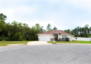 a white house with a driveway in front of it at Beachy Bliss the perfect stay in Navarre