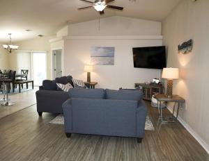 a living room with two couches and a flat screen tv at Beachy Bliss the perfect stay in Navarre