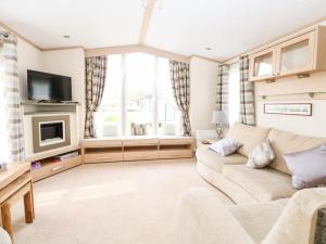 a living room with a couch and a tv at 5, Foxburrow Hang in Great Yarmouth