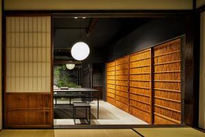 a dining room with wooden doors and a table at YADORU KYOTO HANARE Washi No Yado in Kyoto