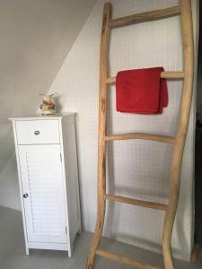 a ladder with a red towel on it next to a cabinet at Fischerhus Lütt Hauke 69 qm Traudel in Altwarp