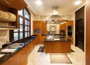 a large kitchen with wooden cabinets and a sink at Family Home in Oiartzun with Mountain View in Oiartzun