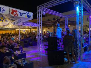 a crowd of people sitting around a stage at night at Villa Dacla in Lampedusa