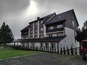 a large white building with a fence in front of it at Hotel Petra in Hrabušice