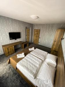 a bedroom with a large bed and a flat screen tv at Hotel Petra in Hrabušice