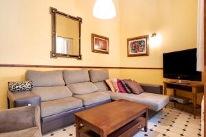 sala de estar con sofá y TV en Casa Pepa, en Chiclana de la Frontera