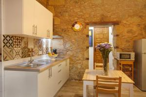 a kitchen with a sink and a table with a vase of flowers at Casa Mamayana in Telde