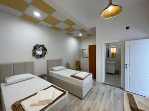 a room with two beds and a bathroom at Hostel Izvor in Podgorica