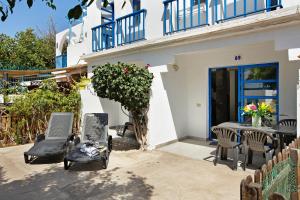 Un patio con una mesa y sillas frente a una casa. en Playmar6970, en Maspalomas