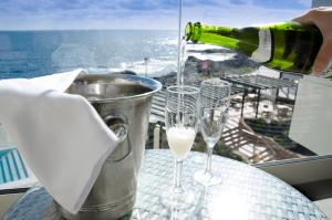 a bottle of wine is being poured into two wine glasses at Hotel Ereza Mar - Adults Only in Caleta De Fuste