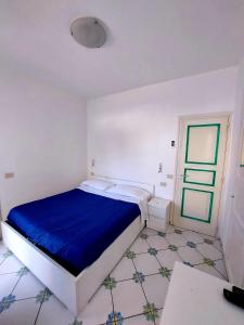 Schlafzimmer mit einem Bett mit blauer Bettwäsche und Fliesenboden in der Unterkunft La solara in Anacapri