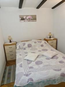 a bedroom with a bed with two night stands and two dressers at Apartments Pinezić in Martinšćica