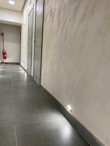 pusty korytarz z betonową ścianą z drzwiami w obiekcie Hotel Poker w mieście Neapol