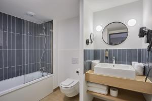 布拉尼亚克Appart Hotel Odalys City Toulouse Blagnac Aéroport的带水槽、马桶和镜子的浴室