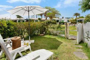 einen Picknicktisch mit einem Sonnenschirm im Hof in der Unterkunft Be Room Villa Tinguaro in Maspalomas