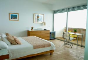 1 dormitorio con cama, escritorio y silla en Iris Zahara, en Zahara de los Atunes