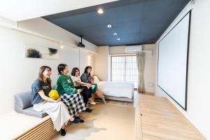 een groep mensen in een hotelkamer bij Minn Shin-Osaka in Osaka