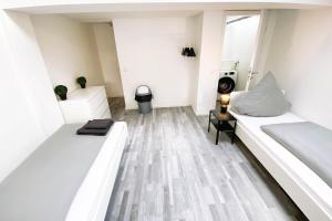 Habitación blanca con 2 camas y ventana en 2 room house for workers, en Linz am Rhein