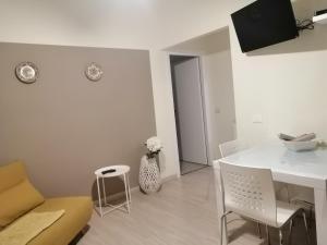 Una sala de estar blanca con una mesa y sillas blancas. en Balcone sul mare, en Monterosso al Mare