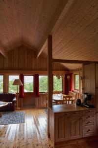 a kitchen and living room with wooden ceilings and a table at Melkevoll Bretun Camping in Stryn