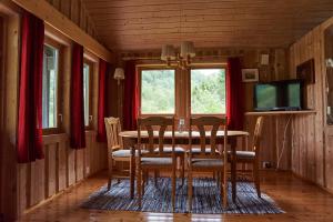Melkevoll Bretun Camping في Briksdalsbre: غرفة طعام مع طاولة وكراسي وتلفزيون