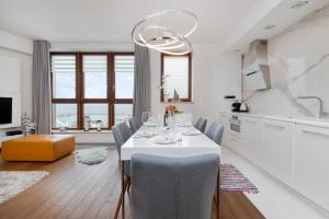 格地尼亞的住宿－Sea Towers 15th floor Apartment with Sea View by Renters Prestige，一间配备有白色桌椅的用餐室