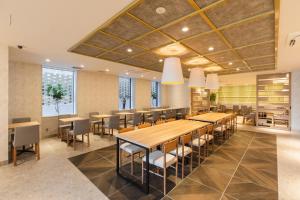 a dining room with wooden tables and chairs at SOTETSU GRAND FRESA TAKADANOBABA in Tokyo