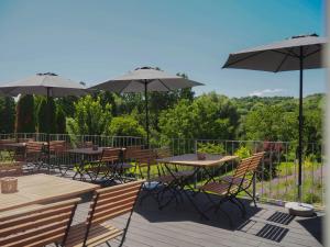una terraza con mesas y sillas y sombrillas en Weinhotel Wasem en Ingelheim am Rhein