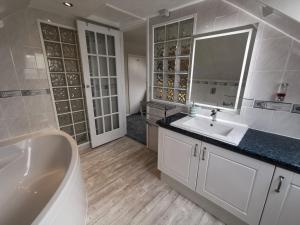 a bathroom with a tub and a sink and a mirror at Aquarius B&B in Newquay +47 photos