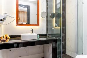 a bathroom with a sink and a shower at Hotel Les Ambassadeurs in Casablanca