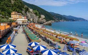 Una playa con un montón de sombrillas y el océano. en Balcone sul mare, en Monterosso al Mare