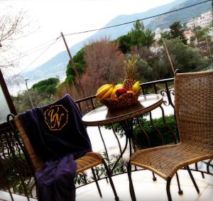 a table with a basket of fruit on a balcony at Villa Nickolas in Paleo Tsifliki