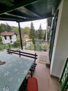 a patio with a table and chairs and a balcony at Apartman MiG in Berkovac