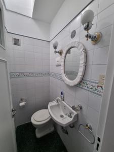 ein Badezimmer mit einem WC, einem Waschbecken und einem Spiegel in der Unterkunft Garibaldi in Mendoza
