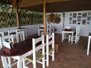 a dining room with white chairs and a table at INZU Lodge in Gisenyi