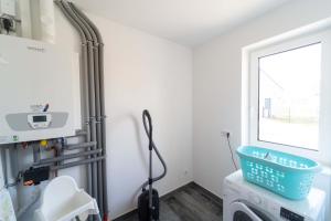 ein Badezimmer mit Waschbecken und Fenster in der Unterkunft Ferienhaus Seeblick am Harkebrügger See mit Sauna und Kamin in Barßel + 16 Fotos