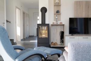 a living room with a fireplace and a tv at Ferienhaus Seeblick am Harkebrügger See mit Sauna und Kamin in Barßel