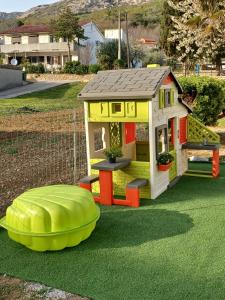een nep speelhuis en een groen oogie bord bij Apartments Polonijo in Baška