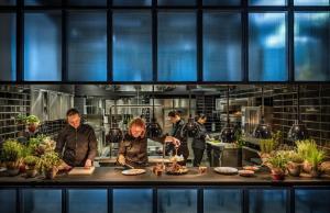 un groupe de personnes préparant des repas dans une cuisine dans l'établissement Adriatic Hotel by Maistra Collection, à Rovinj