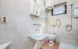 biała łazienka z toaletą i umywalką w obiekcie Apartmani Mile w Krku +25 zdjęć