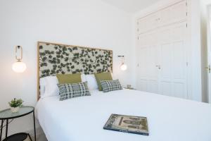a bedroom with a large white bed with pillows at Magno Apartments Redes Terrace in Seville
